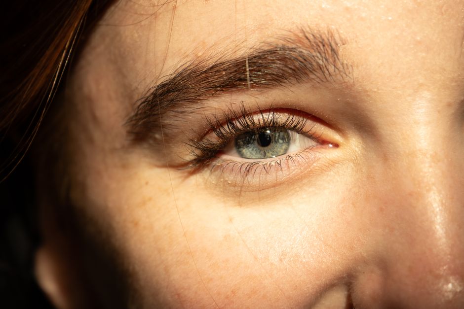 Detailed close-up of a human eye with natural lighting highlighting the iris and eyelashes.