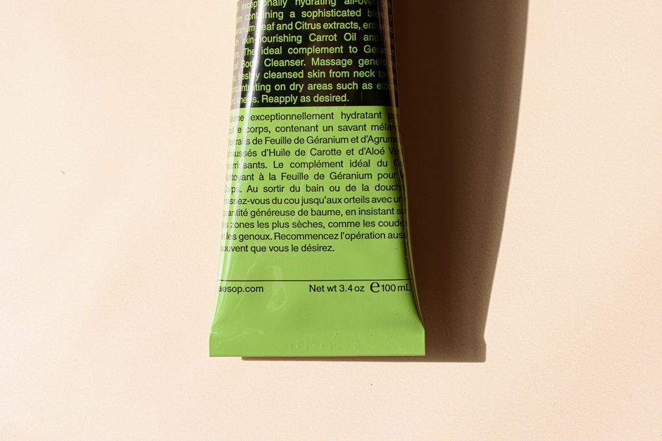 Close-up of a green cosmetic tube with detailed label text, ideal for skincare product ads.
