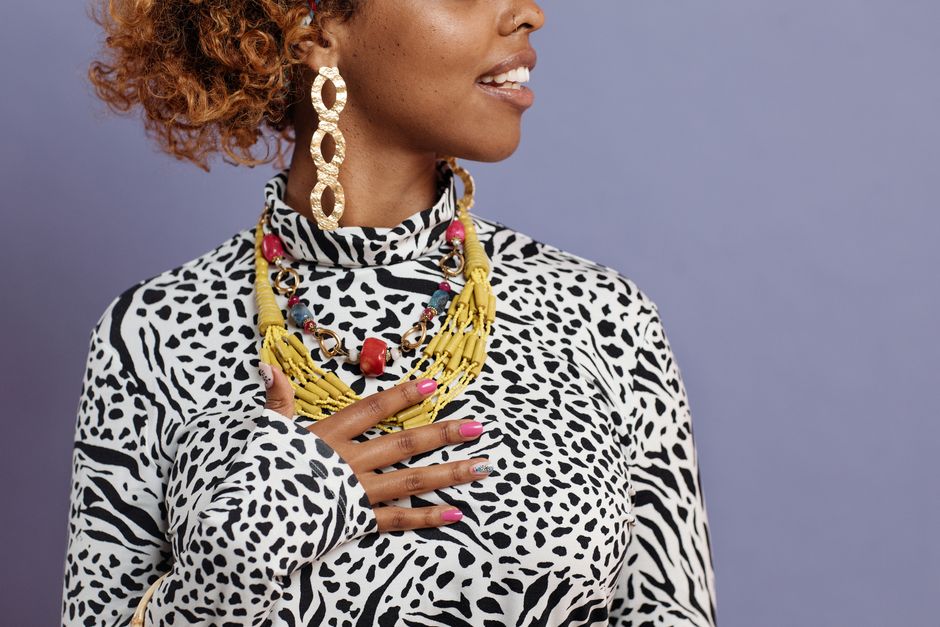 Fashion-forward woman in leopard print attire showcases vibrant jewelry.