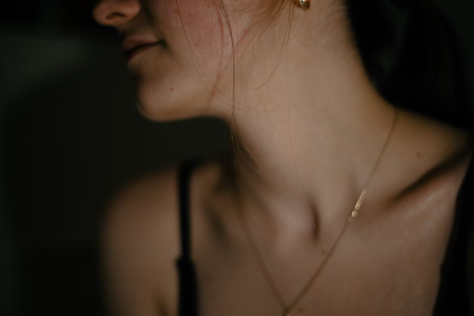 Elegant close-up portrait highlighting a woman's neckline and delicate jewelry.
