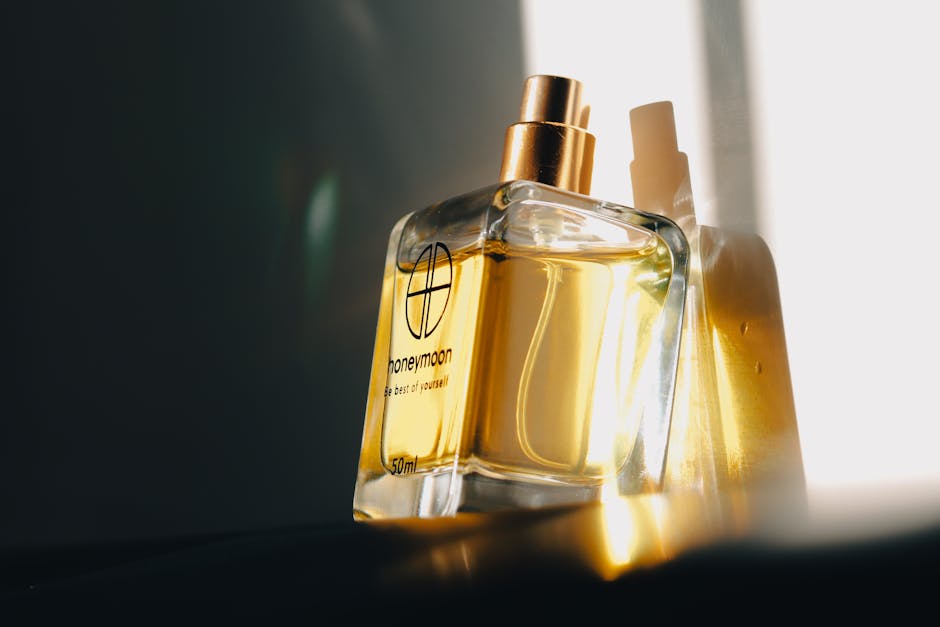 A close-up of a luxurious honeymoon perfume bottle with a gold cap, beautifully lit by sunlight.
