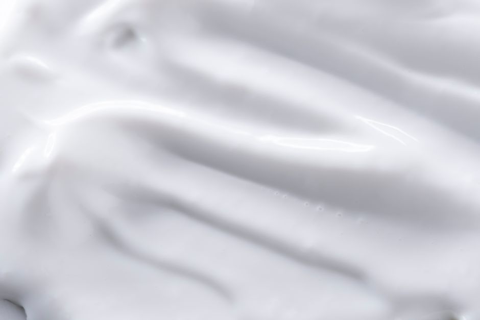 A detailed close-up of a smooth white cream texture, perfect for backgrounds or food imagery.
