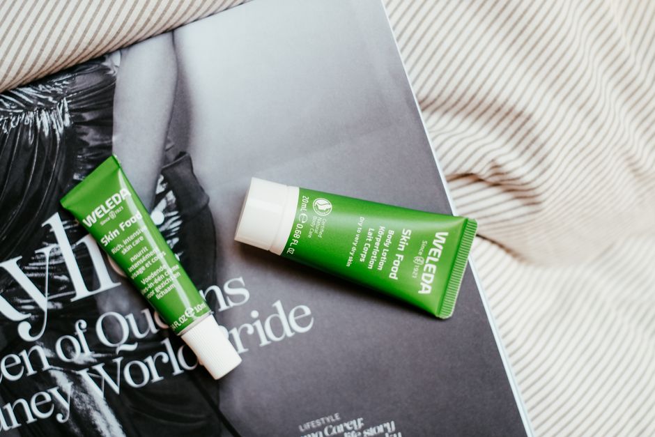 Two Weleda Skin Food tubes placed on a fashion magazine page.