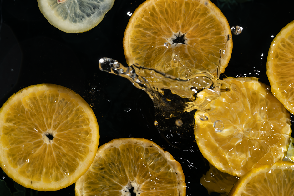 Bright citrus slices splash in water, offering a refreshing and healthy appeal.